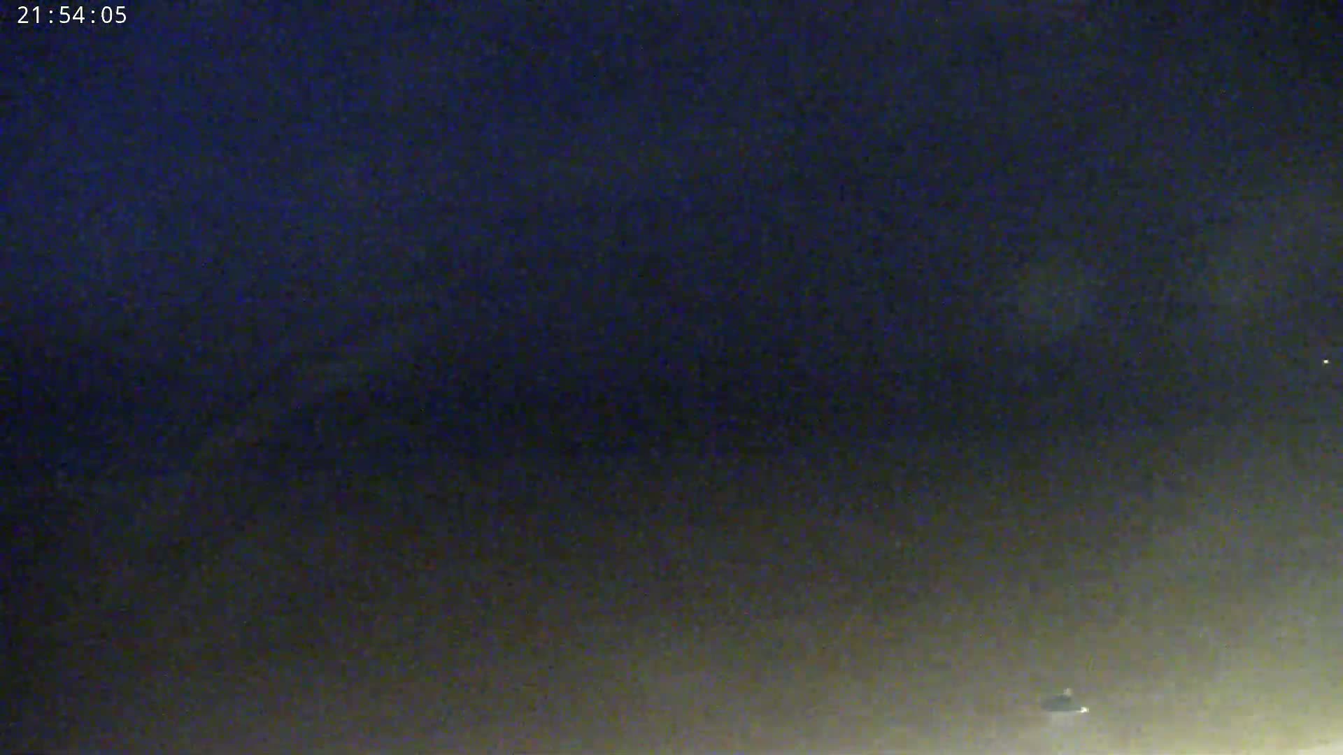 A dark, nighttime scene shows a low-lying fog or haze near the bottom of the frame, with a dark sky above.