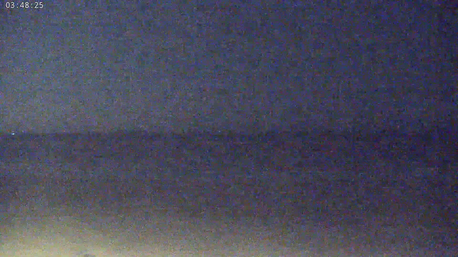 A dark, blurry image shows a body of water under a dark night sky.