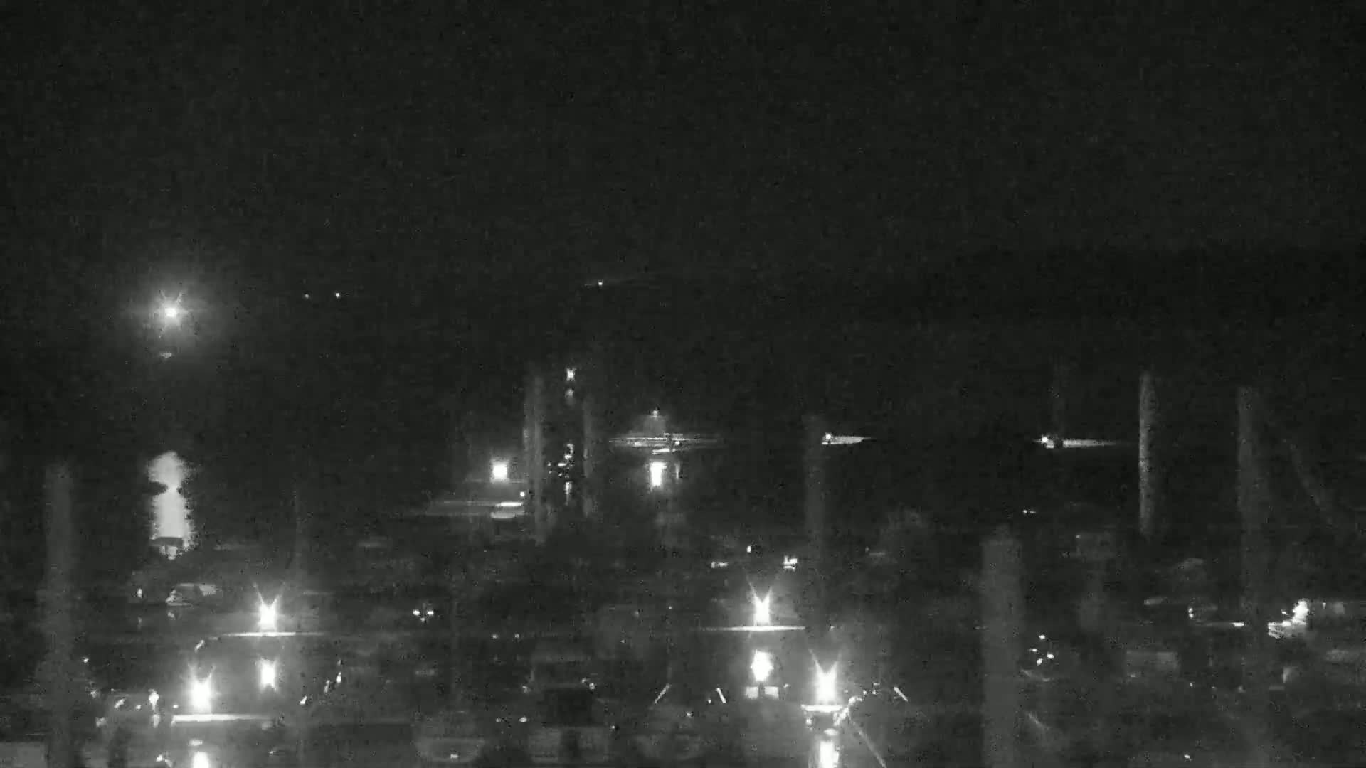 A nighttime, low-light view of an industrial area with several tall structures and numerous smaller lights scattered throughout.