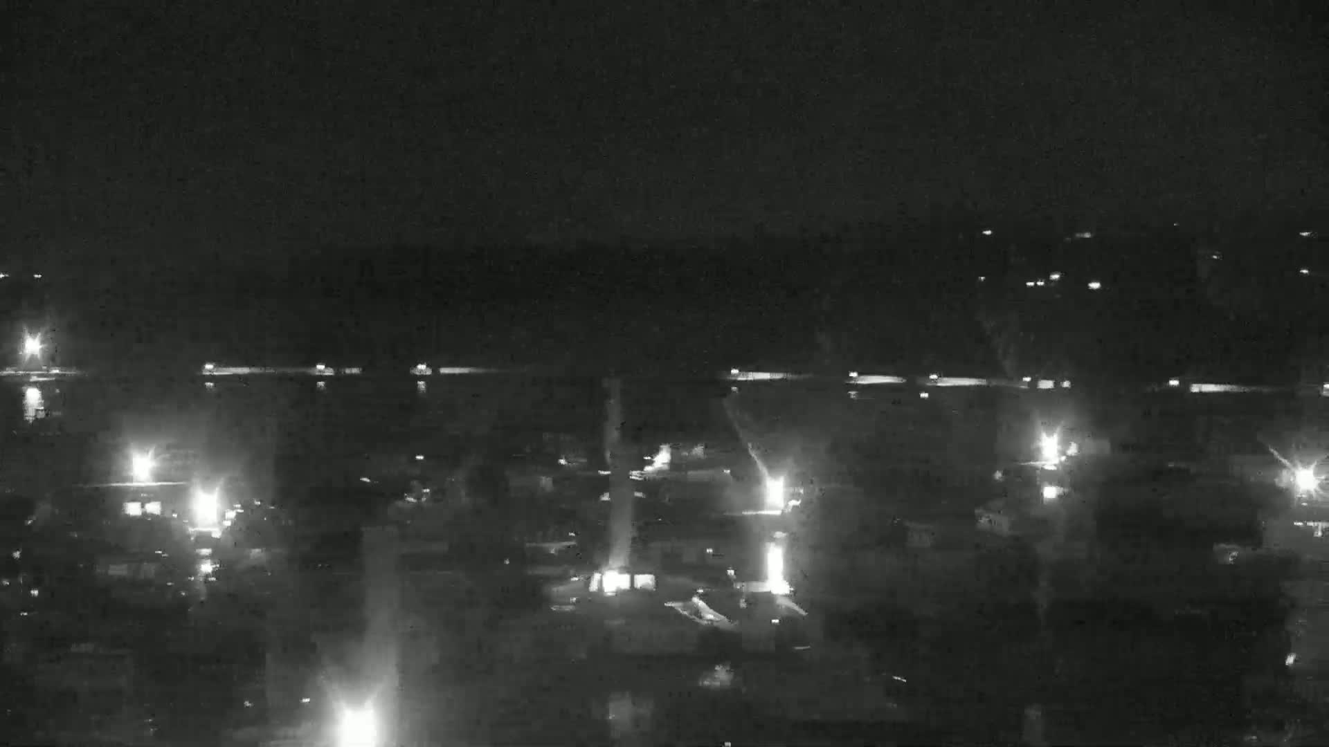 A nighttime, long-range view of a town or city with scattered lights visible, appearing under a clear, dark sky.