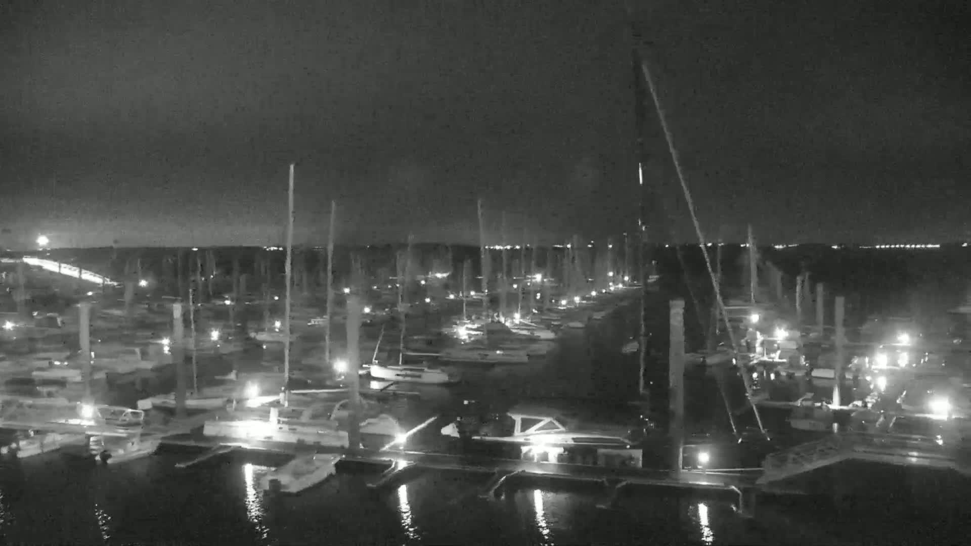 A marina filled with numerous boats at night under a dark sky.