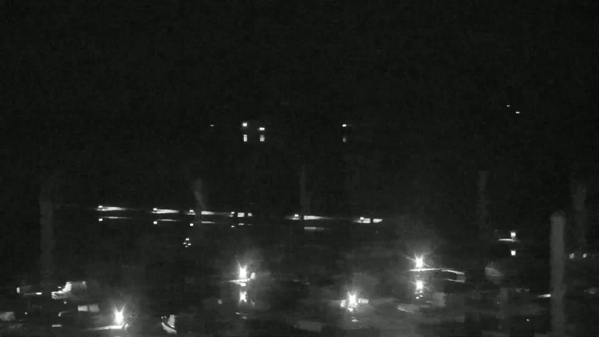 A nighttime, low-light view of an industrial area with scattered lights.