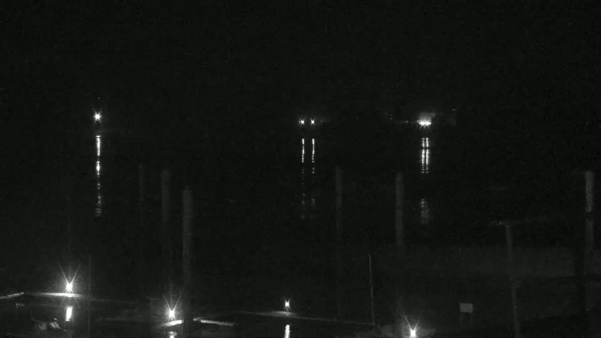 Several lights are visible across a dark body of water at night.