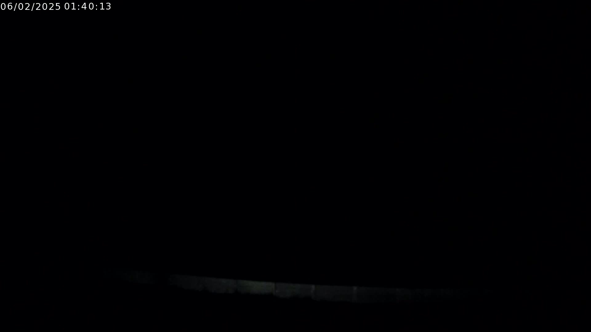 A low-light image shows a dimly lit horizontal line at the bottom of the frame against an otherwise completely black background.