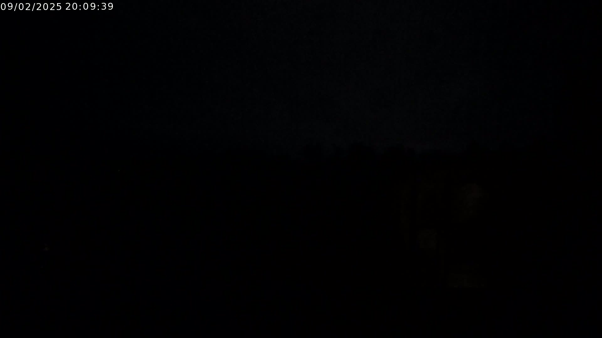 The image shows a very dark, nighttime outdoor scene with barely visible features.