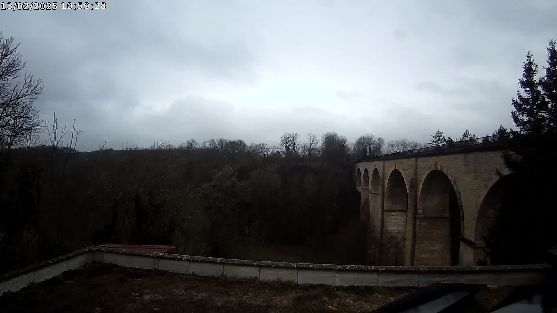 A stone arched bridge is visible through a barren, overcast landscape.