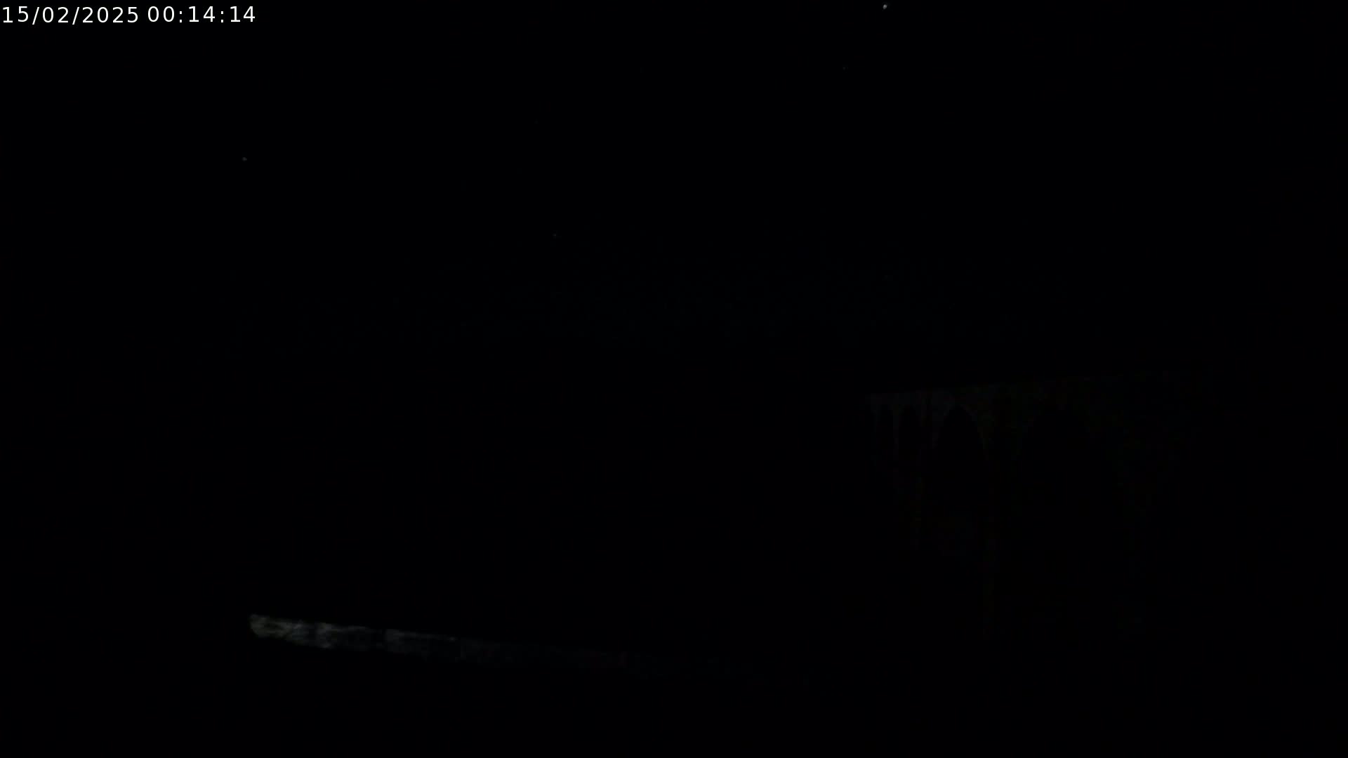 A low-light, nighttime image shows a faint, horizontal line of light near the bottom, possibly a light source or reflection, against an otherwise dark and featureless background.