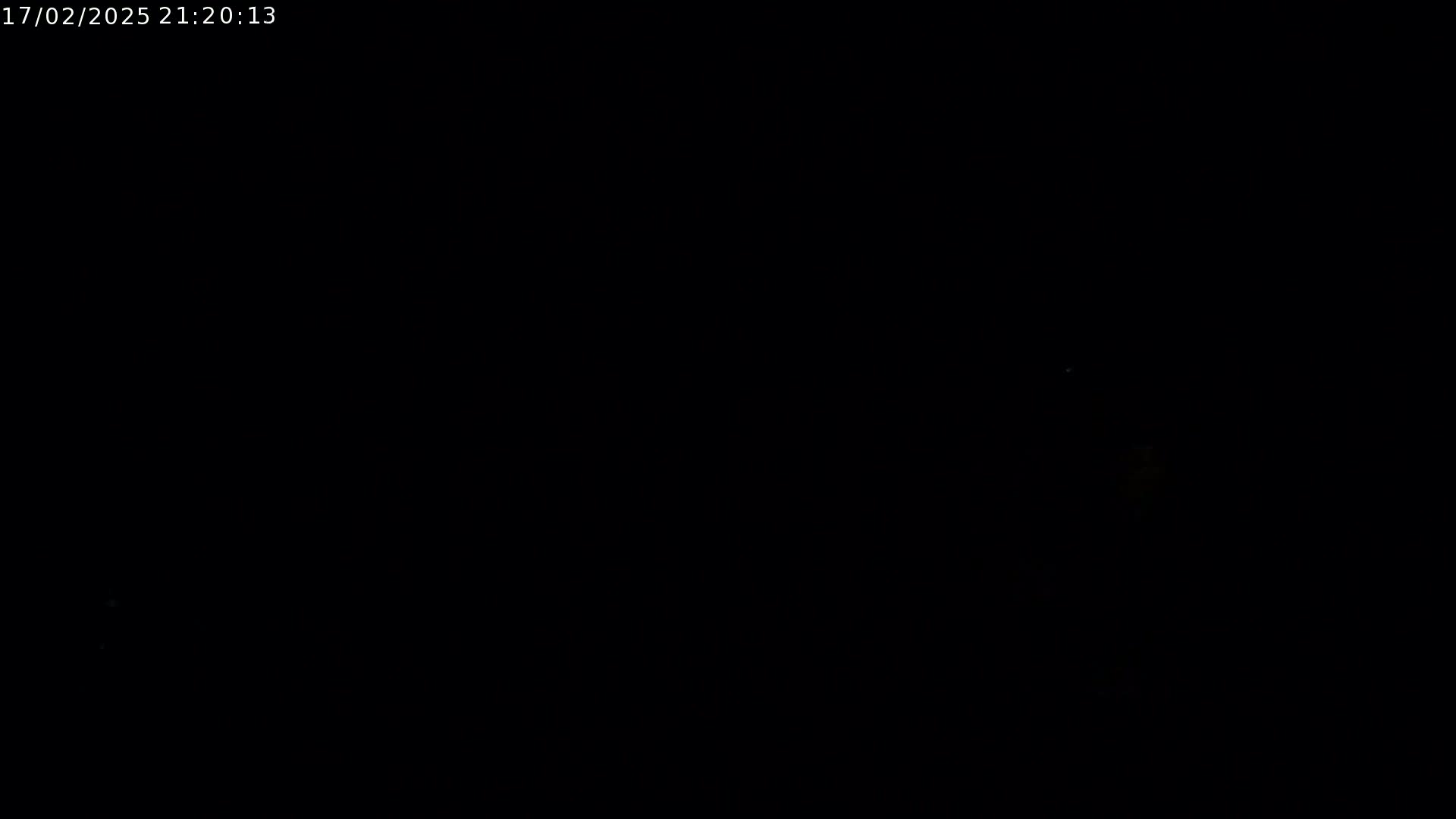 The image is predominantly black, with a few faint, indistinct lights visible in the distance.