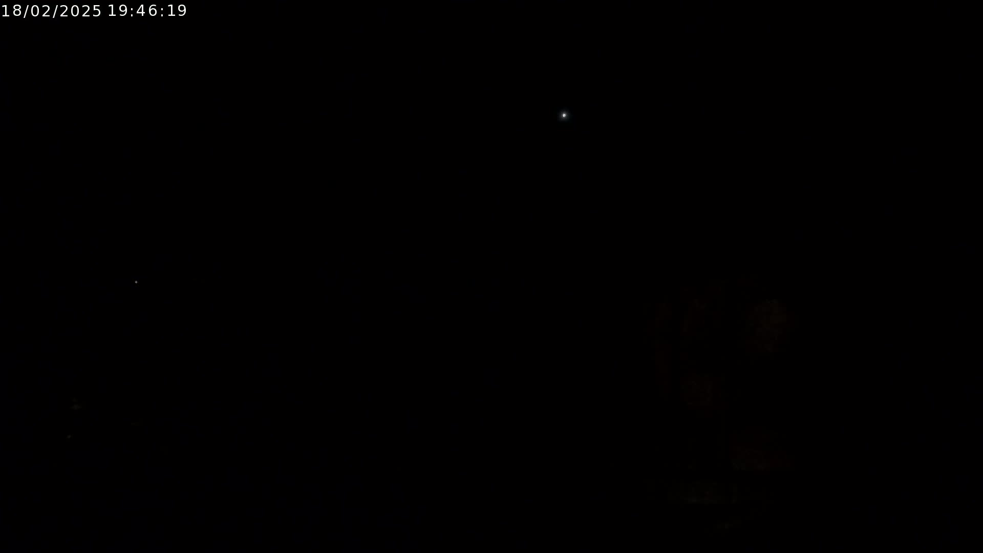 The image shows a dark night sky with a few faint lights visible.