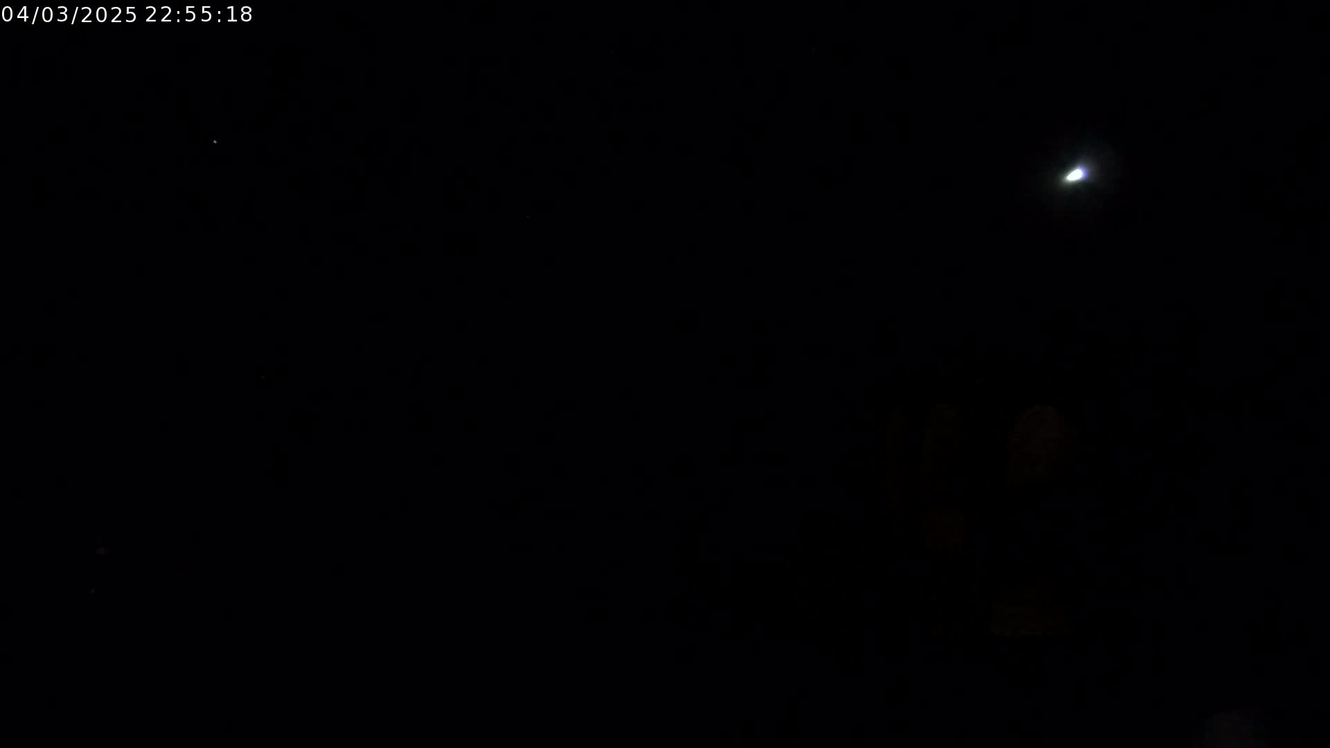 A dark night sky shows a bright light, possibly a planet or star, and some fainter lights that could be stars.
