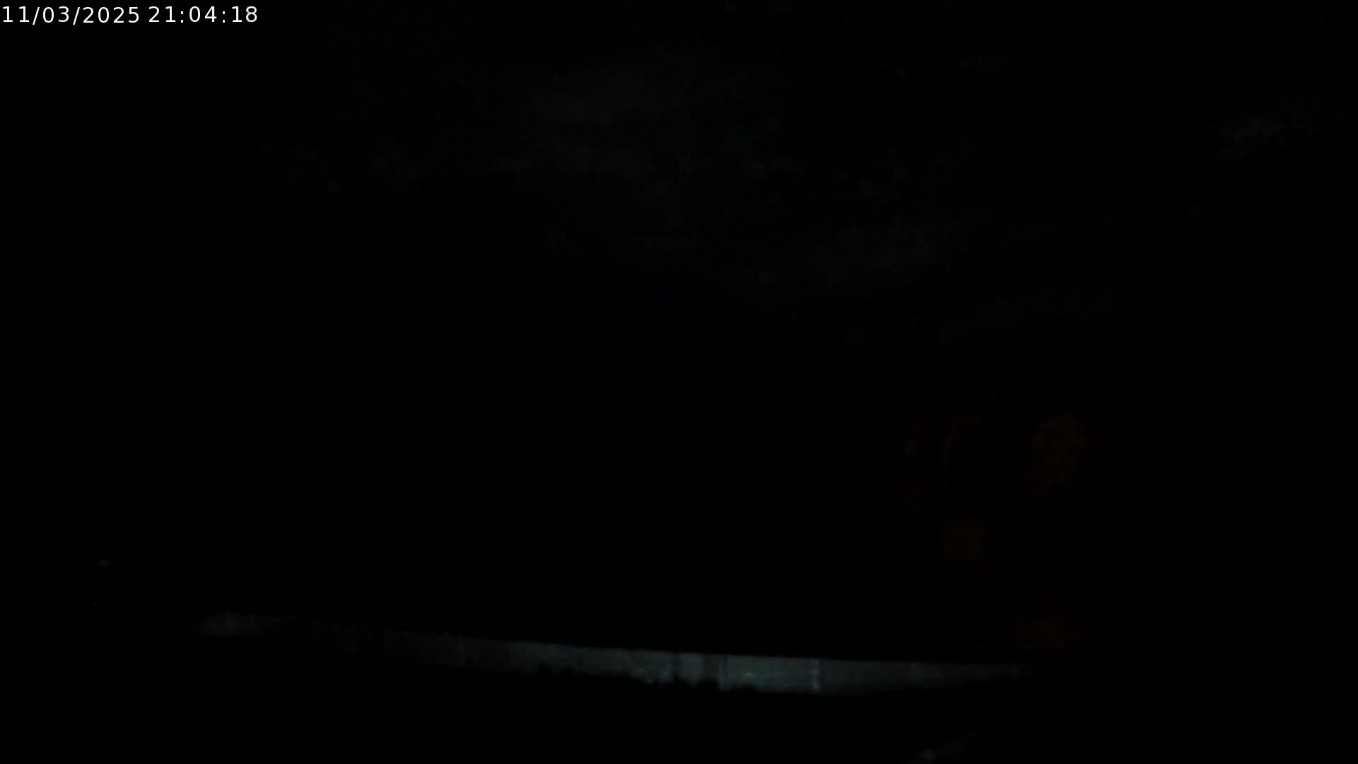 A dark, nighttime scene shows a dimly lit, low horizon line.