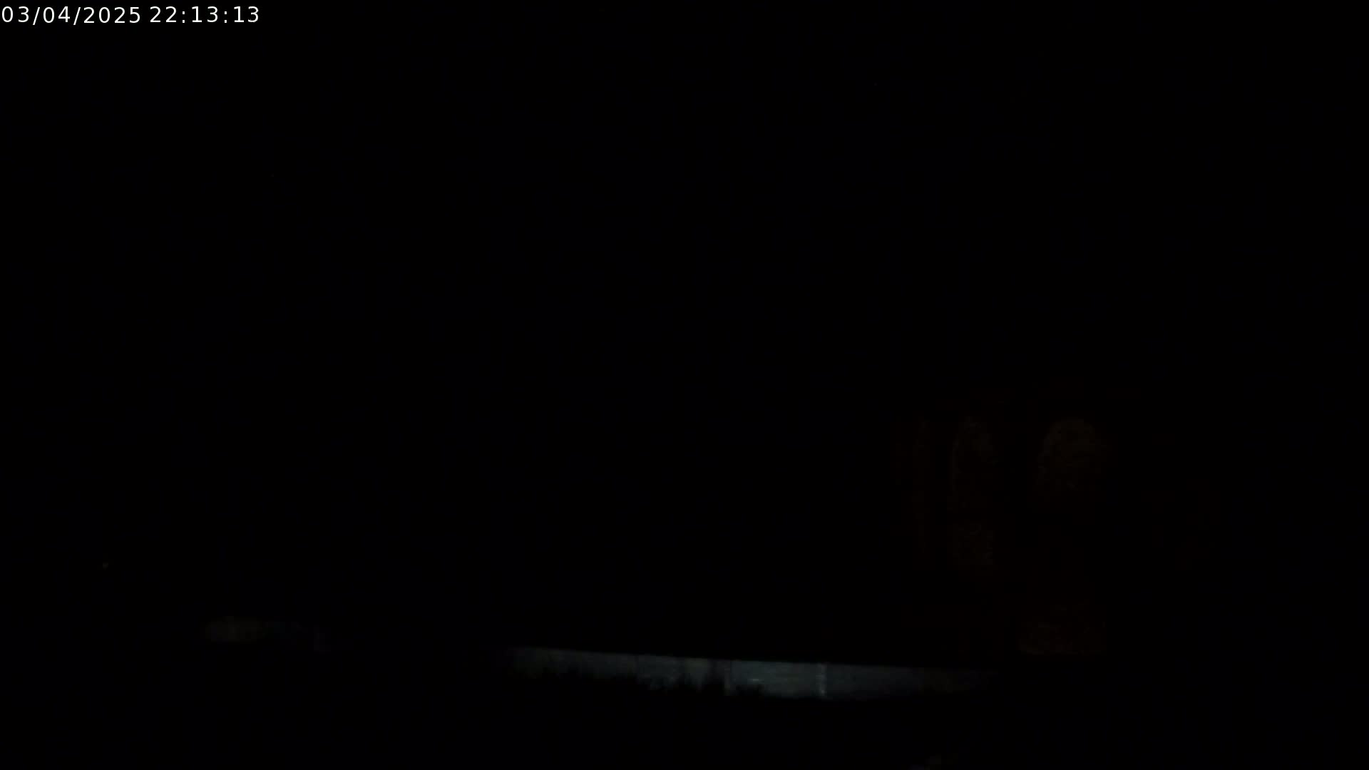A very dark image shows a faint, low horizontal line near the bottom, possibly a ground level, under a completely black sky.