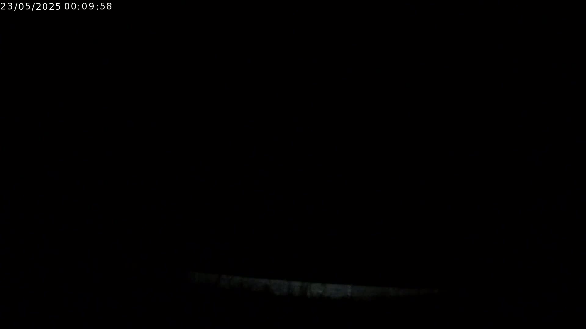 A very dark image shows a faint, blurry line at the bottom, possibly indicating a ground level, under a completely black night sky.