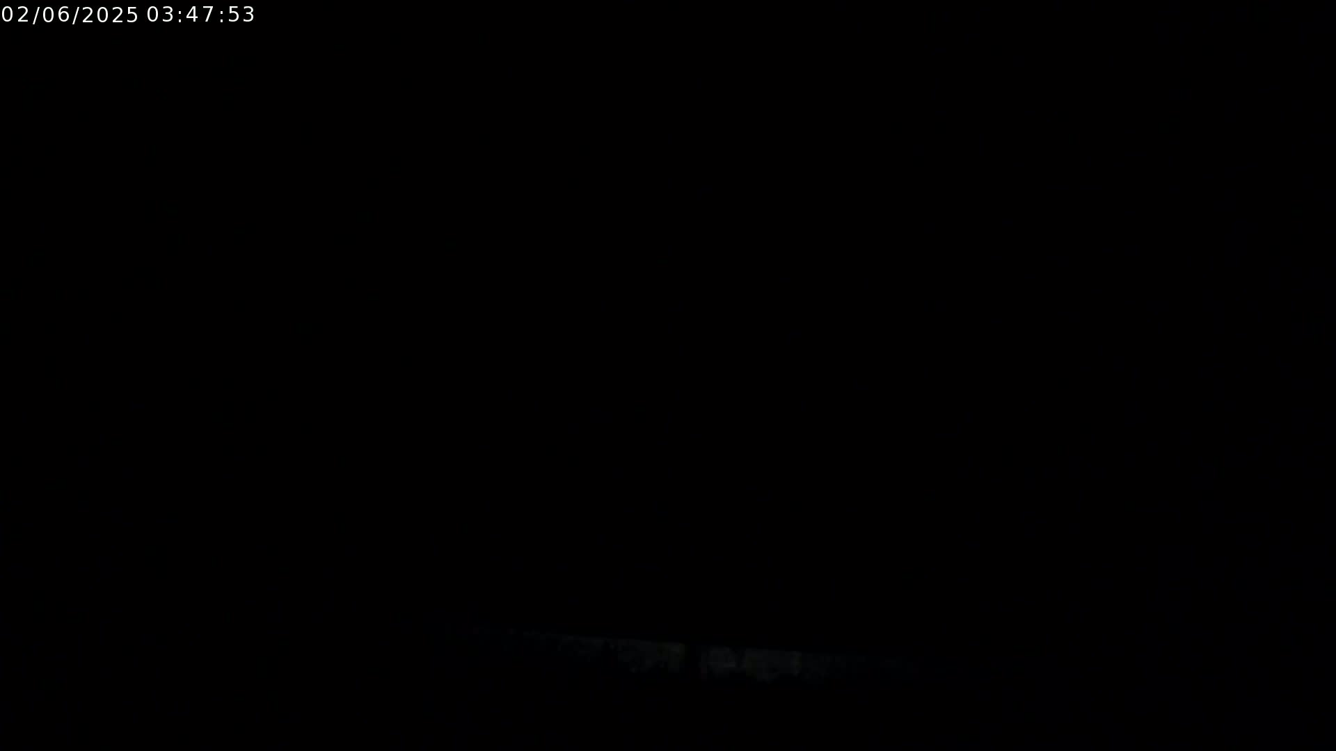 The image is almost entirely black, with a very faint, indistinct light area at the bottom.