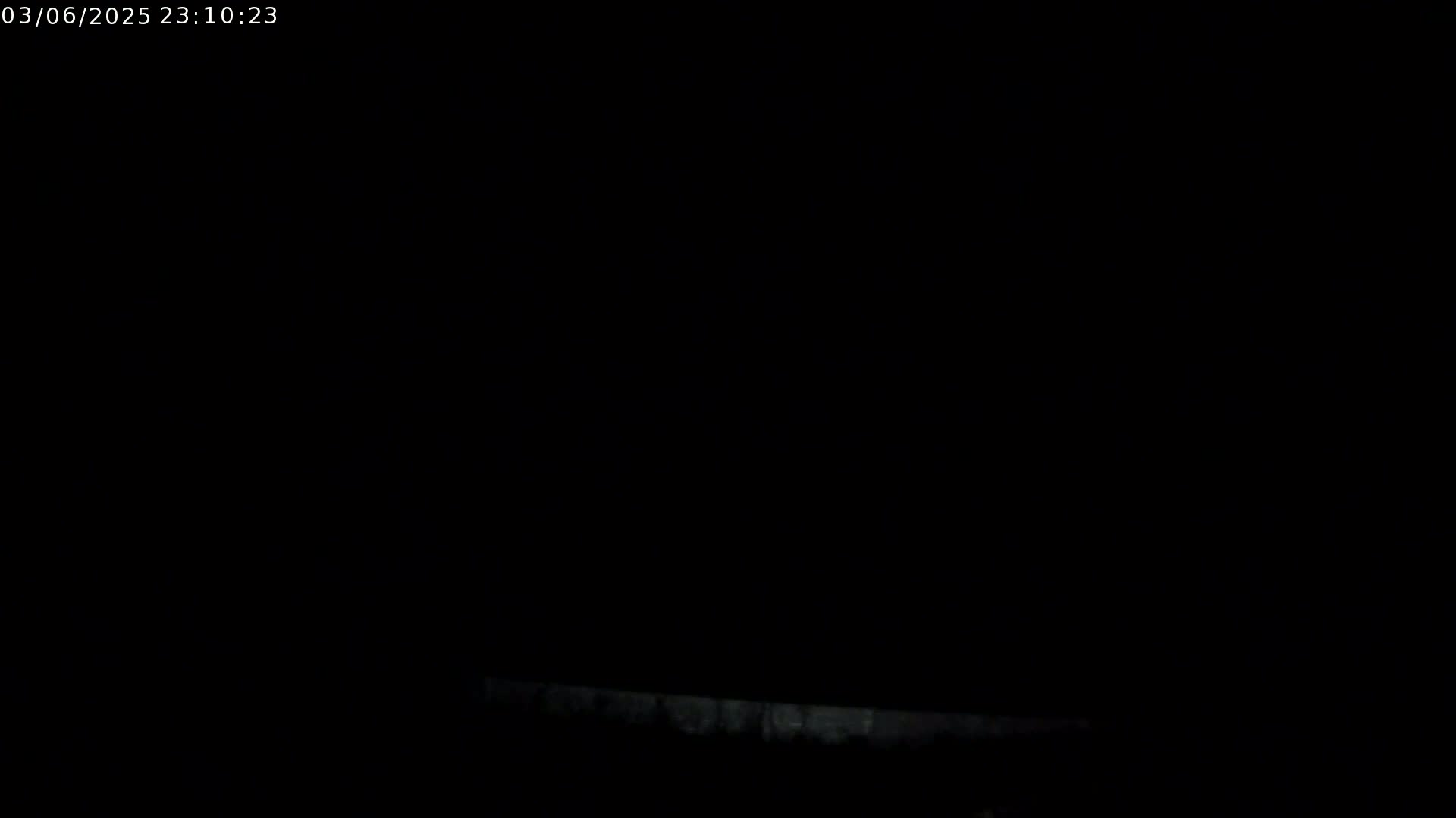 A very dark, nighttime image shows a faint, bright horizontal line at the bottom edge.