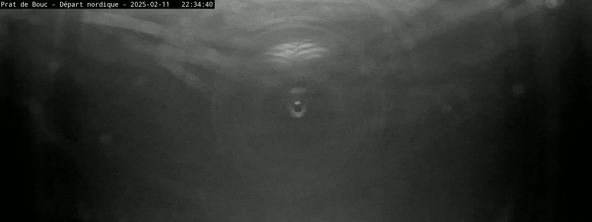 A dark, blurry image shows a mostly featureless, gray-toned scene with faint, lighter areas suggesting possibly overcast conditions or low-light conditions.