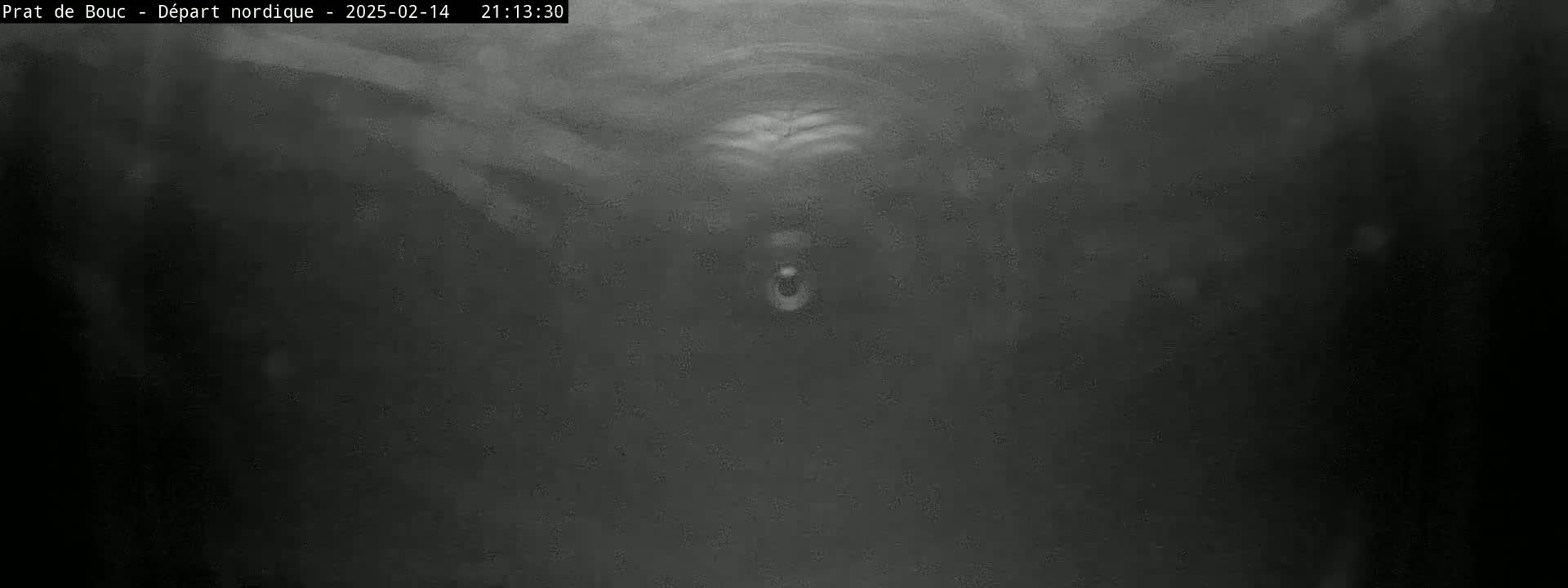 A low-light, grainy image shows a dark, possibly underwater, scene with a small, indistinct object in the center.