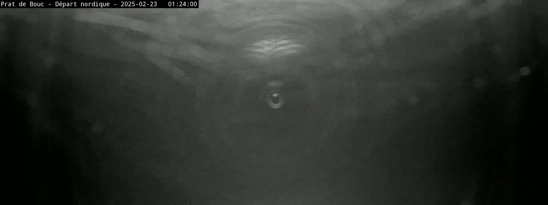 A grainy, dark image shows a blurry, indistinct object in the center, possibly underwater or in heavy fog.