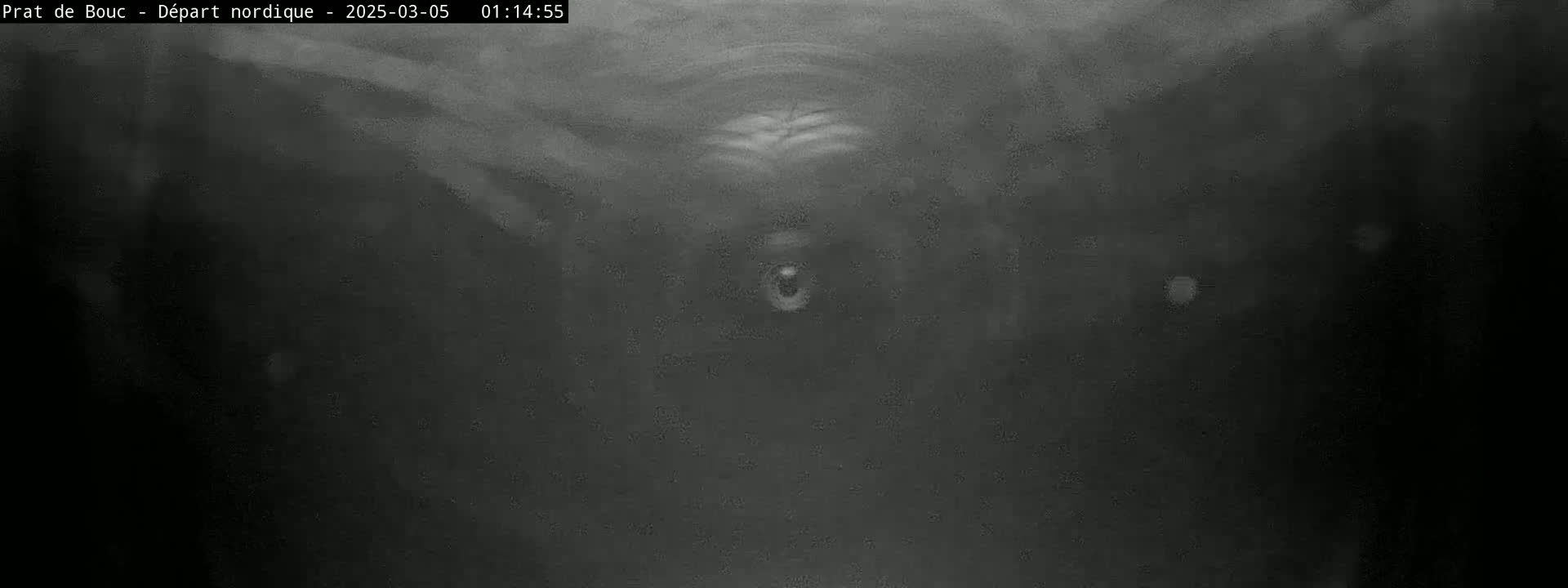 A blurry, dark grayscale image shows what appears to be a low-light view of a tunnel or enclosed space.