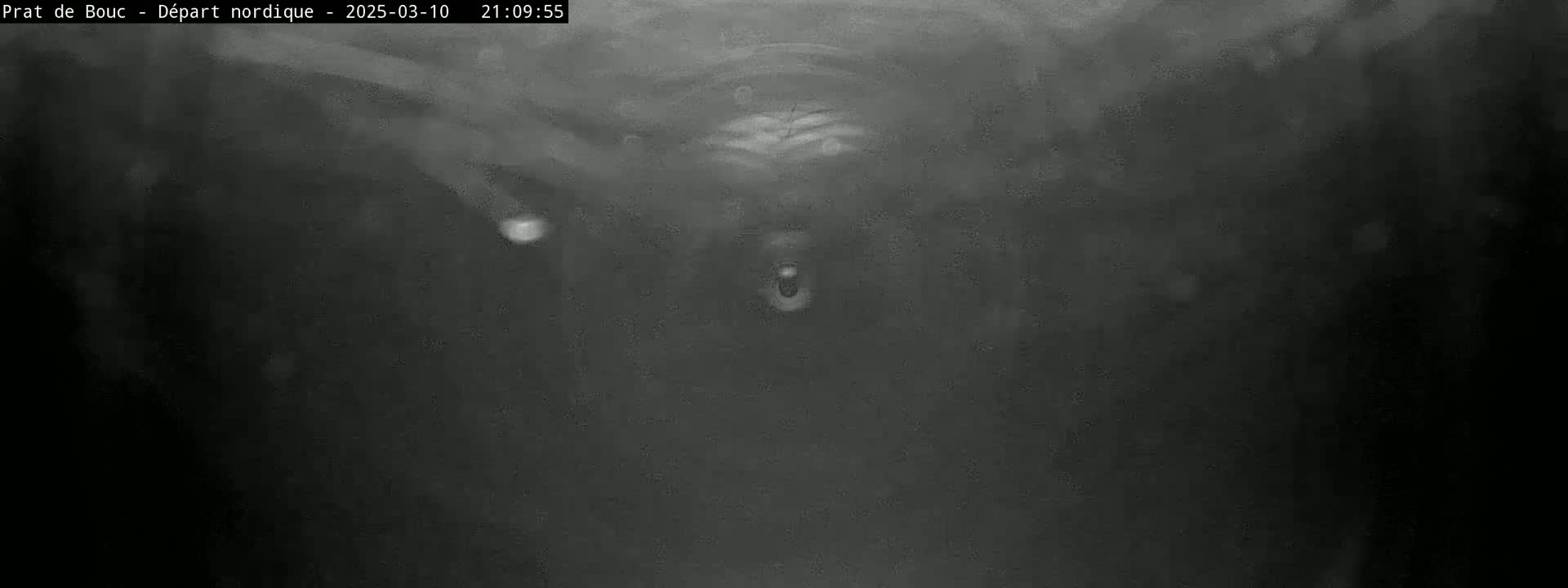 A blurry, dark grayscale image shows an indistinct object in the center, possibly underwater, with particles floating around it.