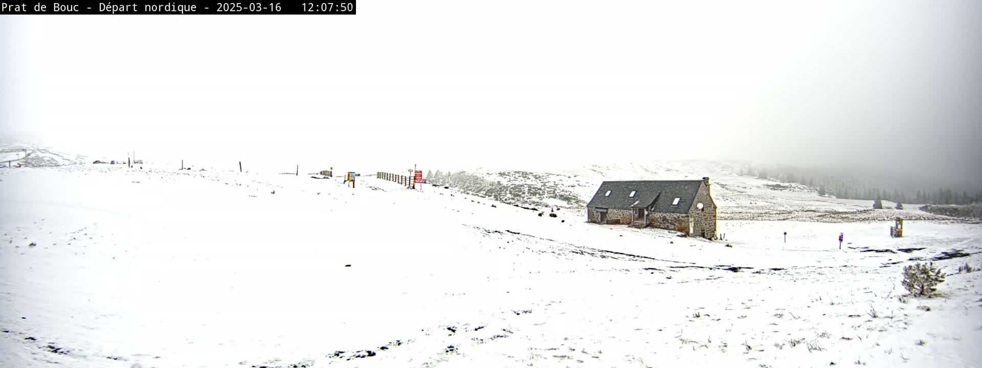 A snow-covered landscape with a stone building and a foggy sky is visible.