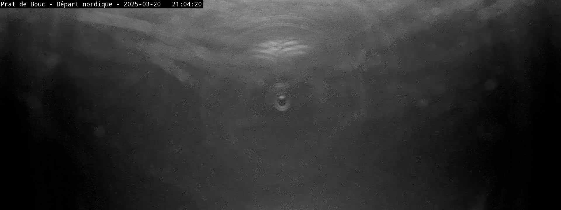 A blurry, dark grayscale image shows an indistinct object in the center against a dark background.
