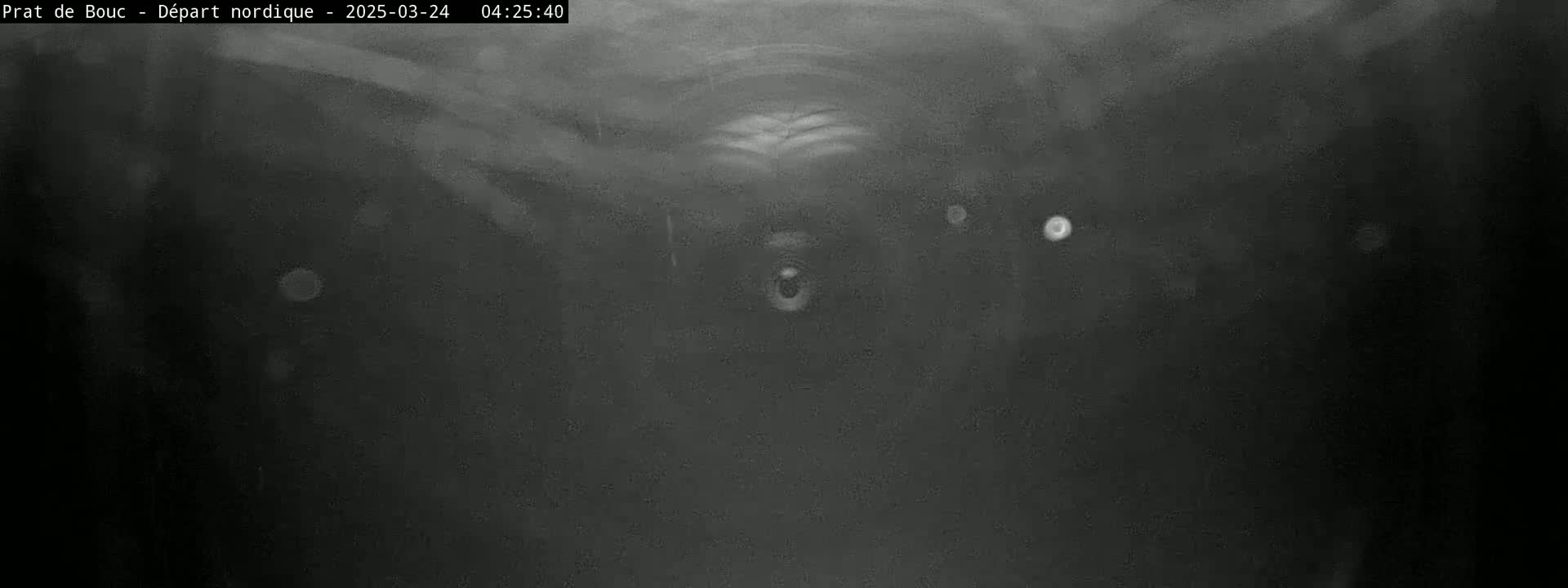 A dark, blurry image shows what appears to be a tunnel-like structure with faint lights visible in the distance under what seems to be nighttime or low-light conditions.