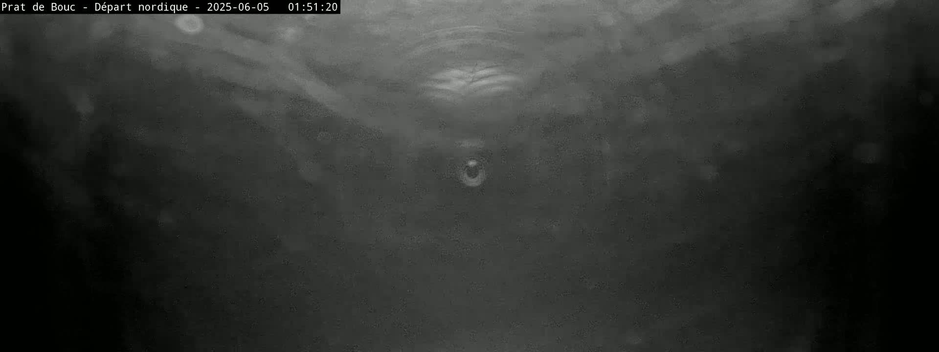 A blurry, dark grayscale image shows a small, indistinct object in the center, possibly underwater or in low-visibility conditions.
