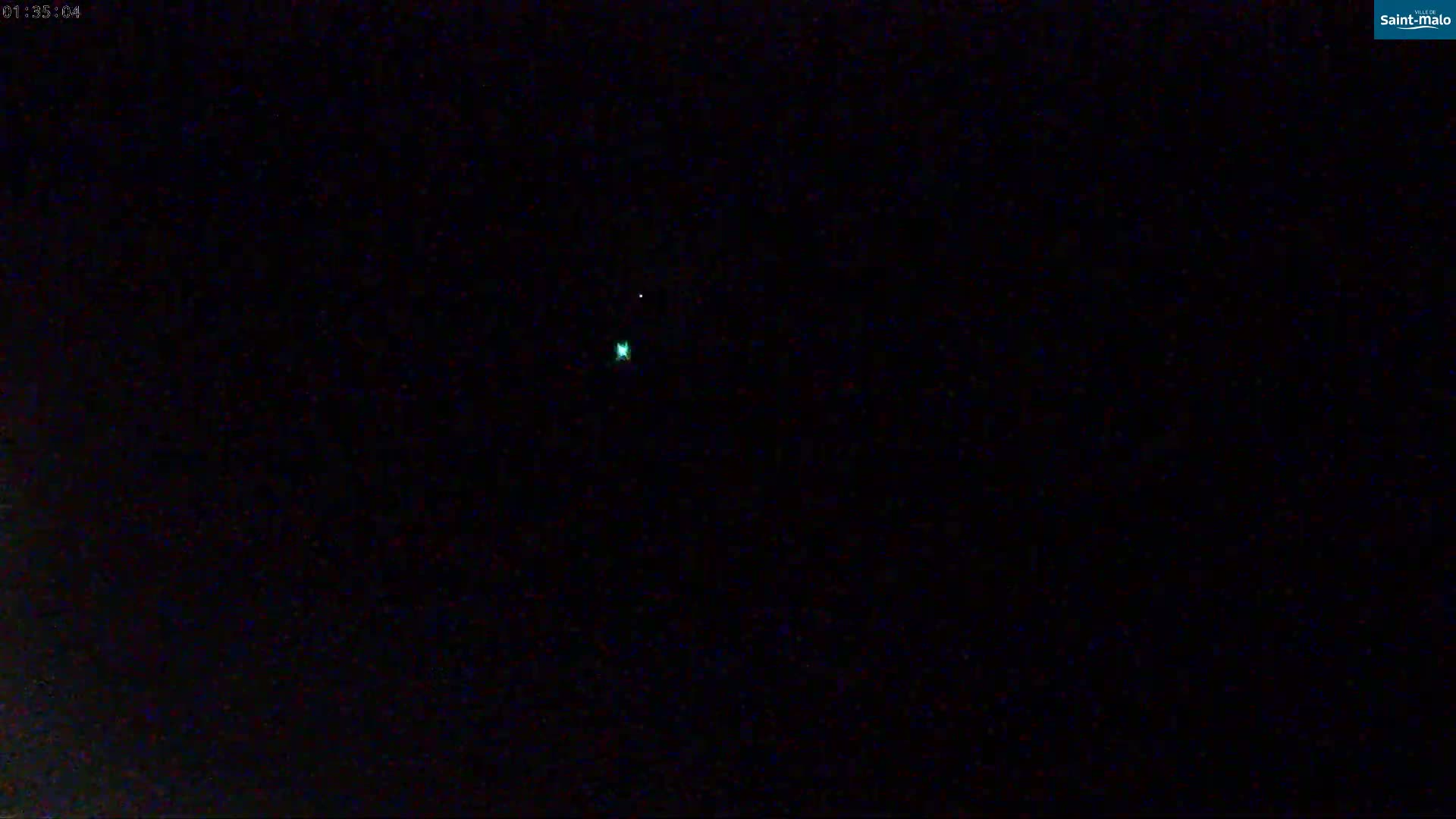 A dark nighttime scene shows two small lights in the distance.