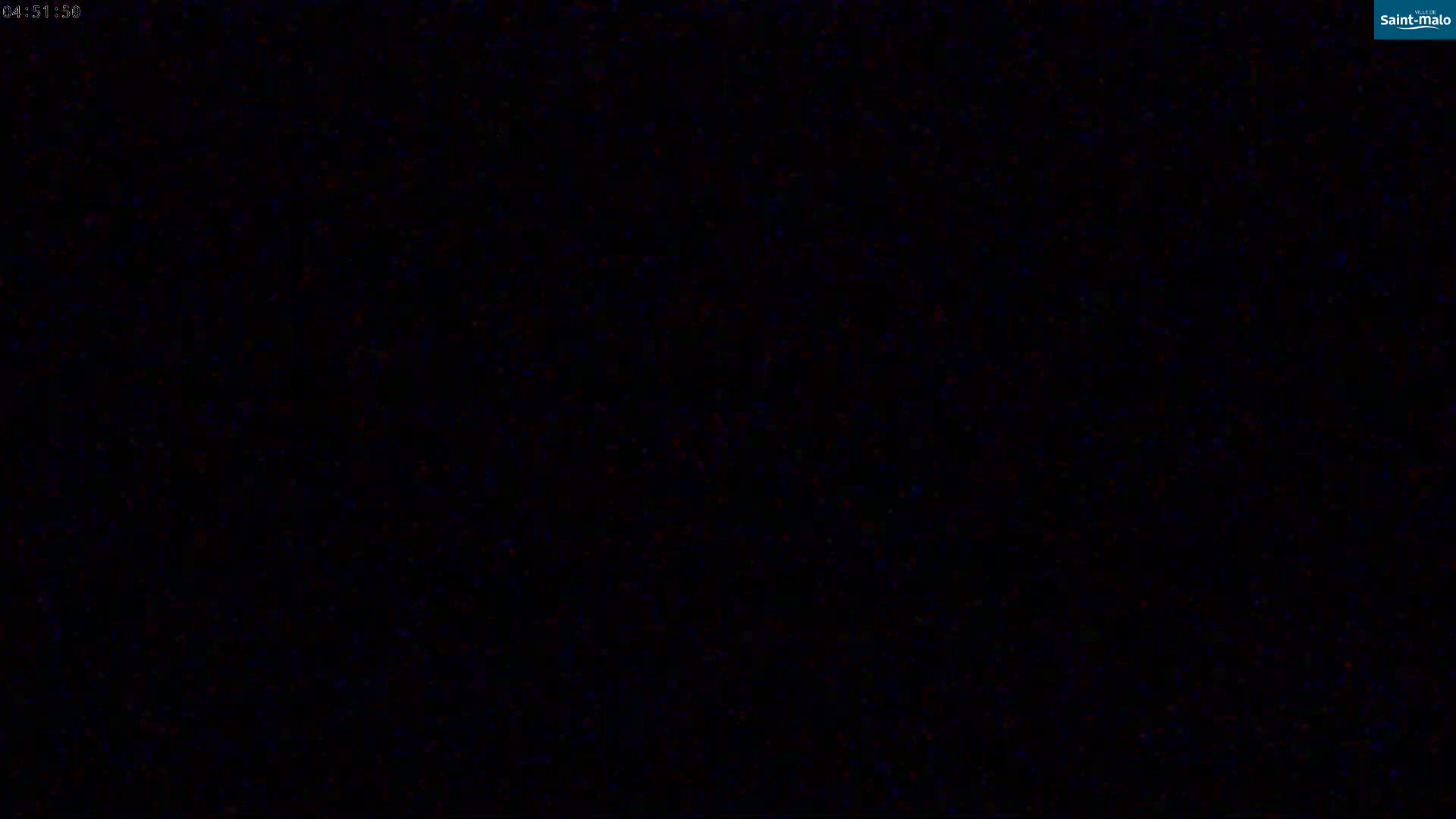 The image is completely black with some minor speckles of color.
