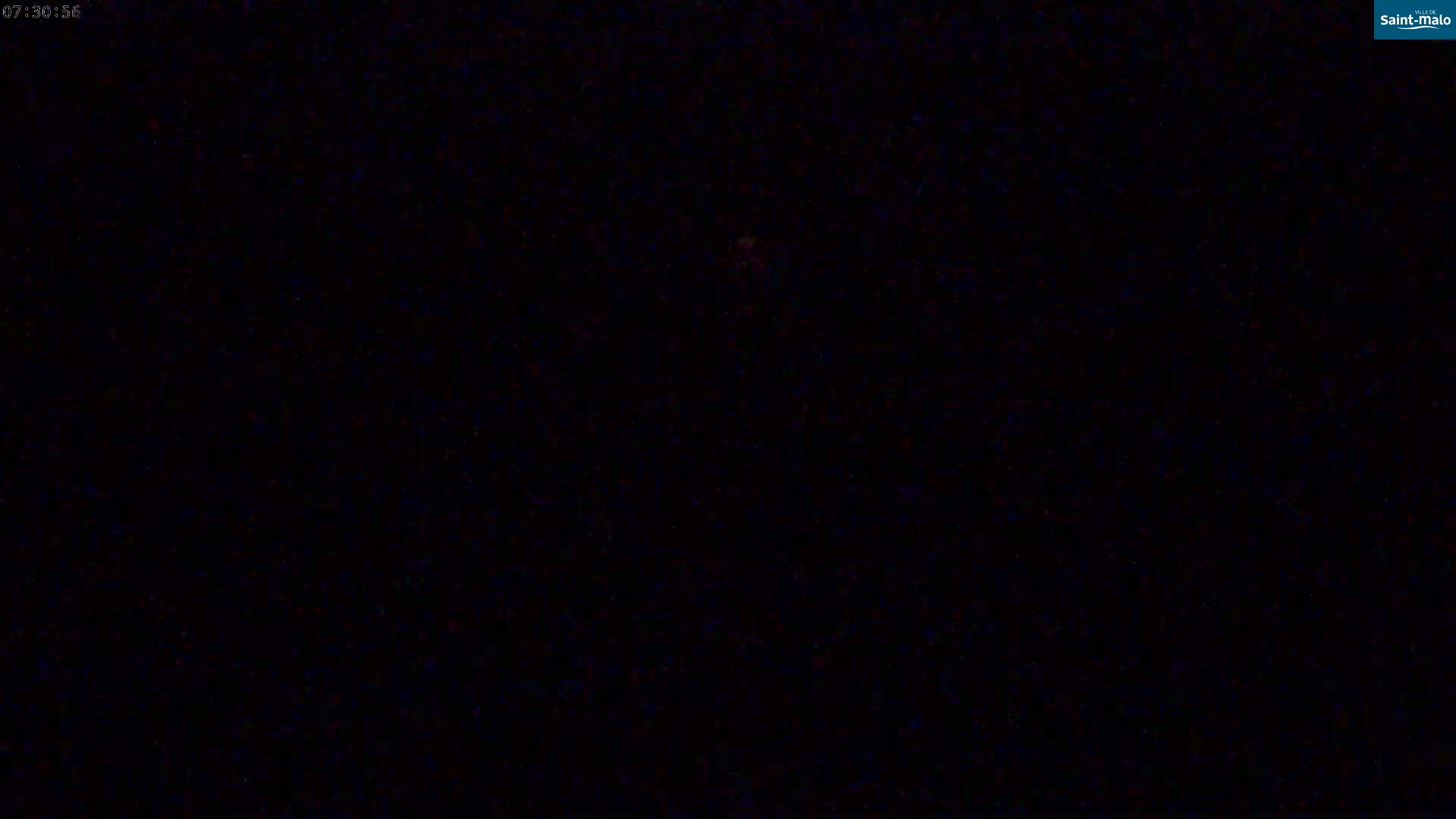 The image is a completely black screen with a few barely visible specks of color.