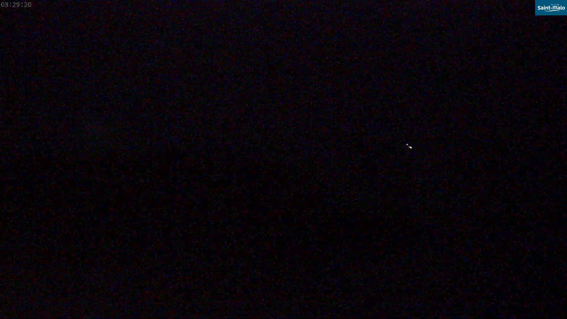 A dark, nighttime scene shows a few faint lights in the sky.