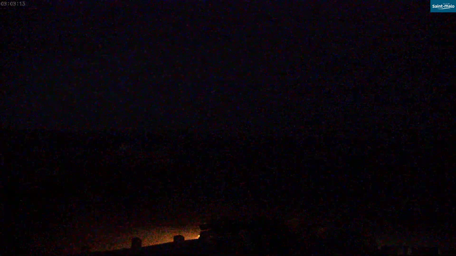 A dark, nighttime scene shows a dimly lit rooftop and a mostly clear, black sky.