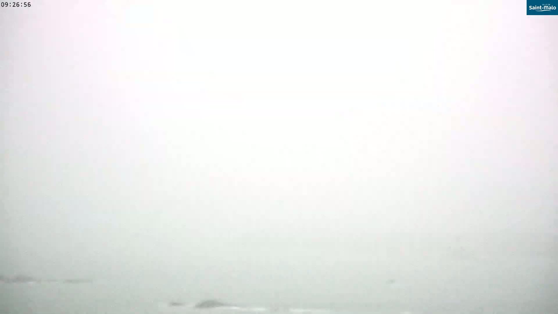 A very foggy or hazy view of a body of water with indistinct landmasses in the distance.