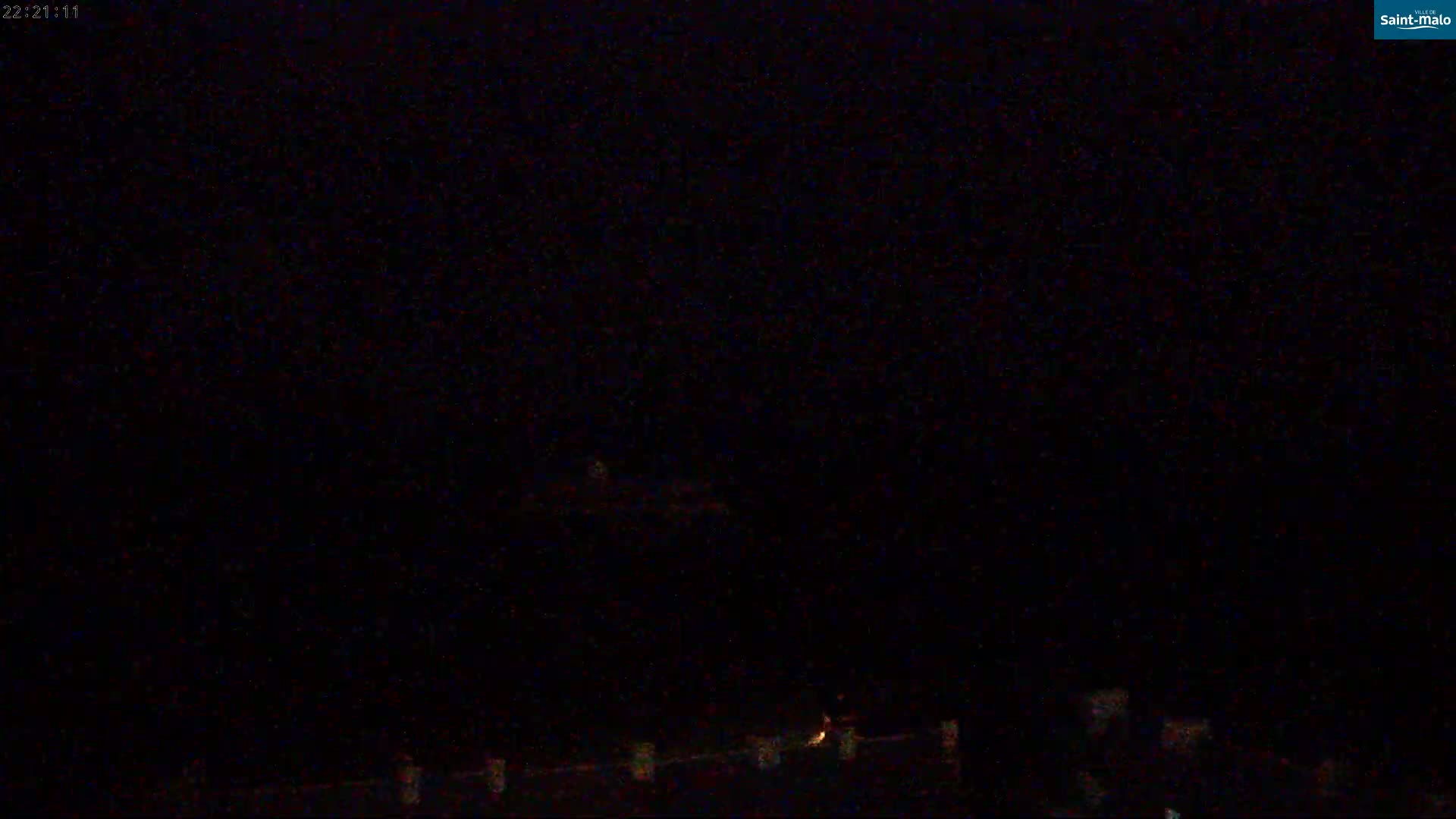 A nighttime, low-light image shows a dark sky and faintly illuminated objects near the bottom of the frame.