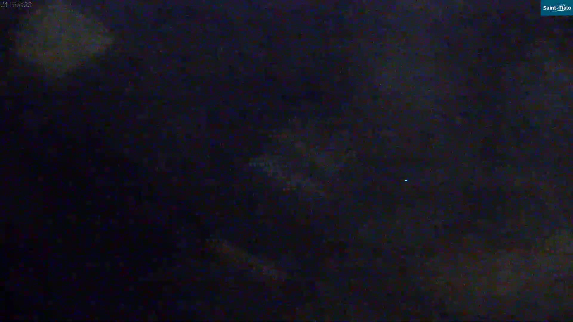 A dark, nighttime image shows a blurry, indistinct view of lights possibly from a city in the distance.