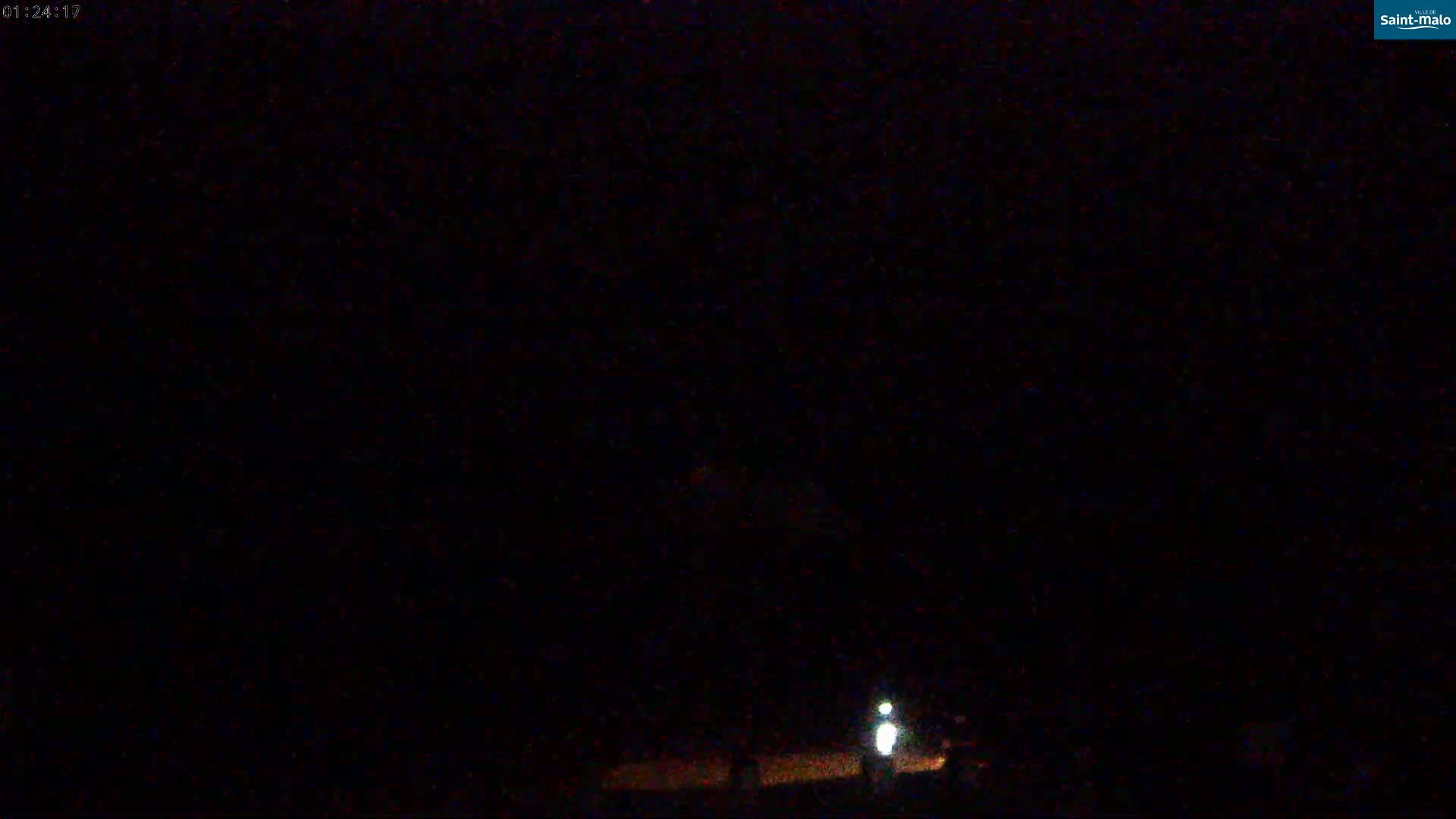 A dim light illuminates a dark, nighttime scene.