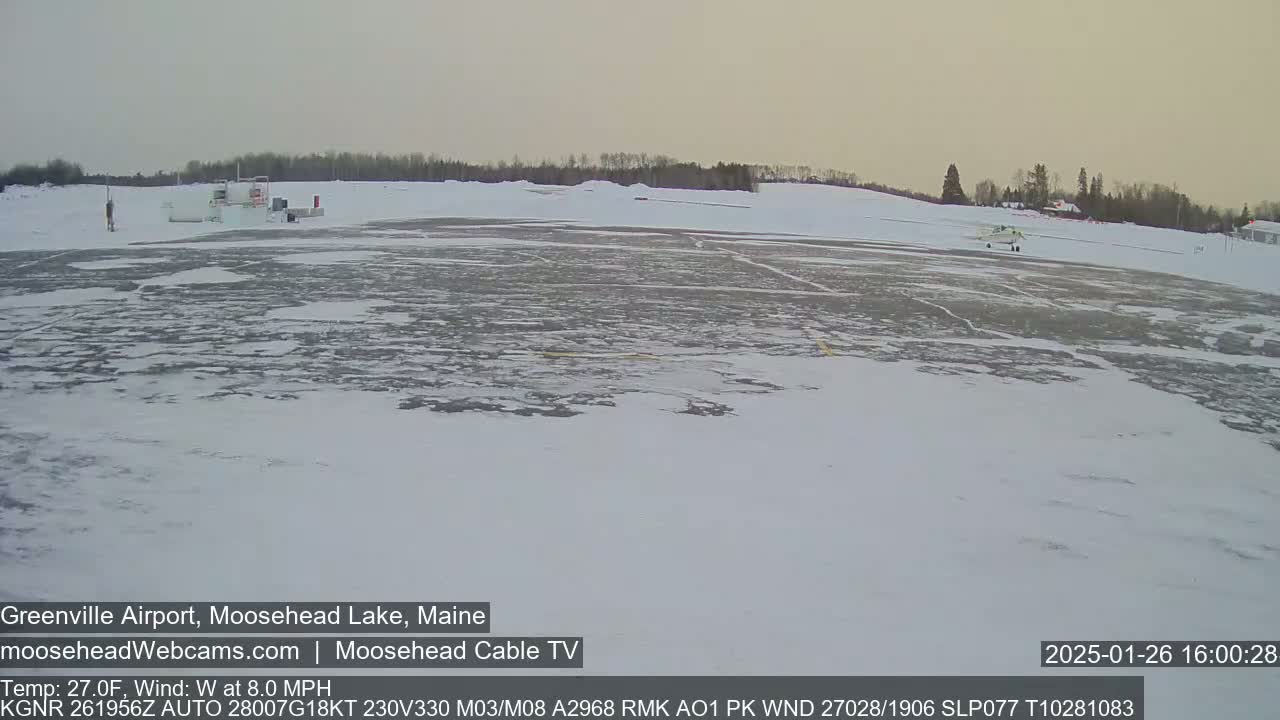 A snow-covered airfield with a small plane on the tarmac is visible under a hazy sky.