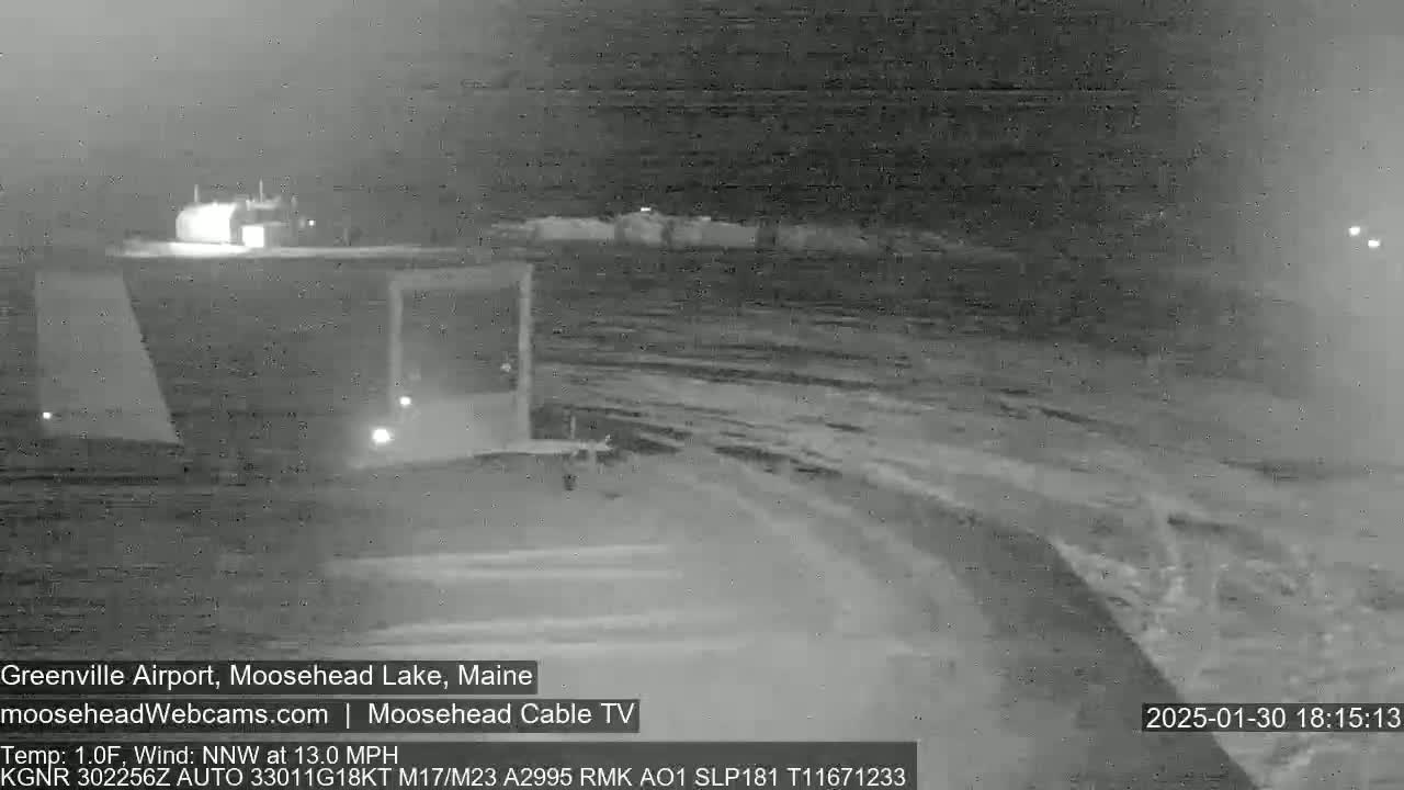 A nighttime, snow-covered airfield is seen under a dark sky with a northwest wind at 13 mph and a temperature of 1 degree Fahrenheit.