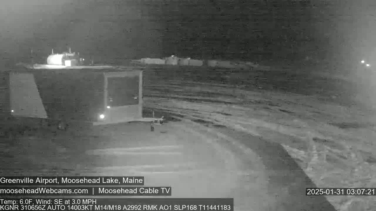 A nighttime, snow-covered airport scene with light wind from the southeast.