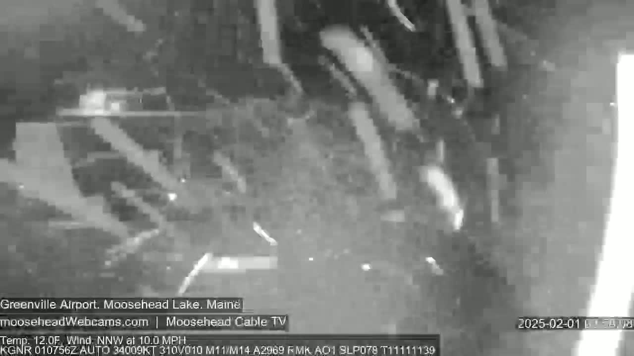 A grainy, nighttime black and white image shows a blurry view of an outdoor scene with a northwest wind at 10 mph and a temperature of 12 degrees Fahrenheit.