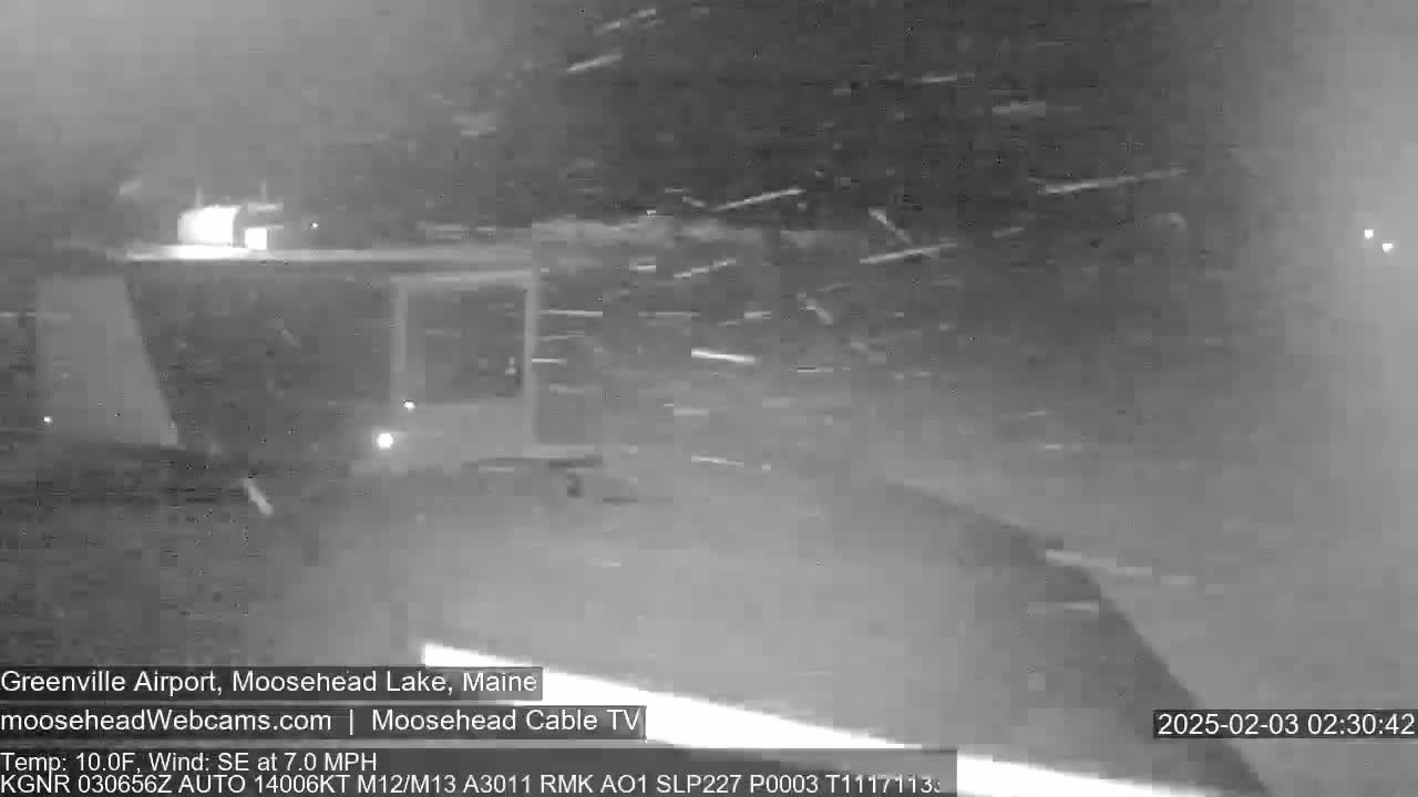 A nighttime, snowy scene shows a building partially obscured by heavy snowfall.