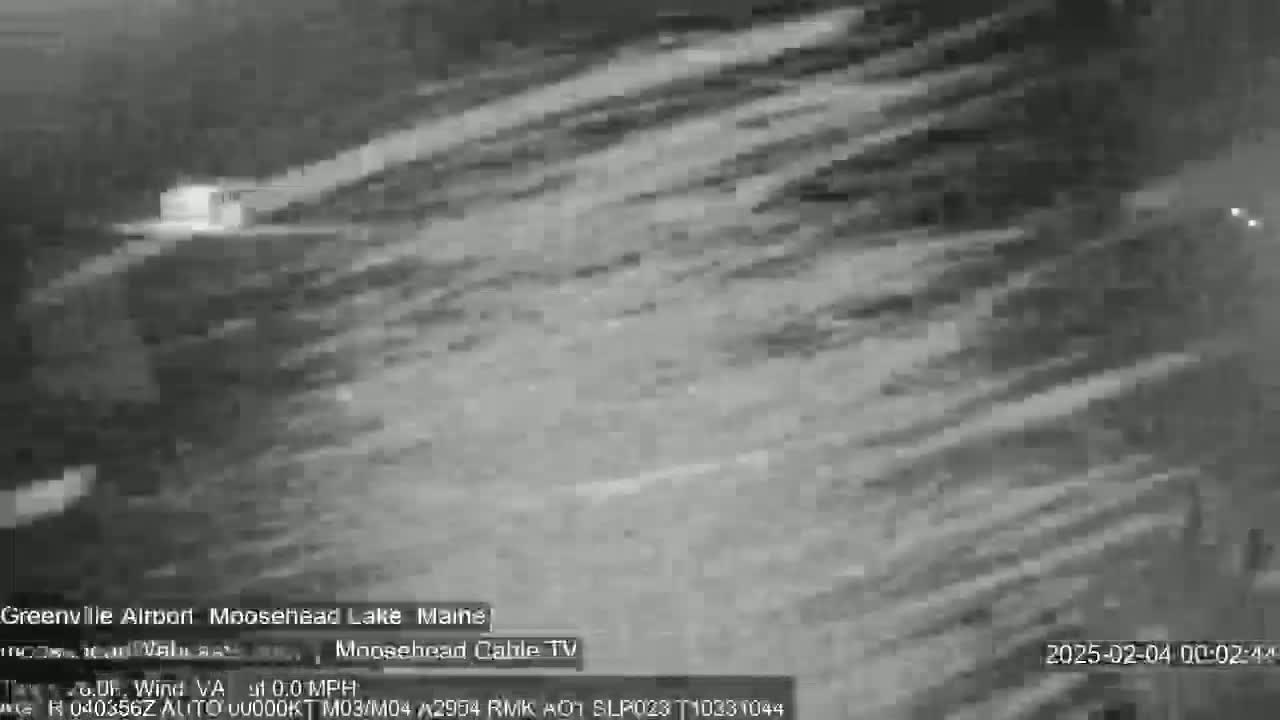 A grayscale image shows a cloudy, nighttime scene with light streaking across the frame.