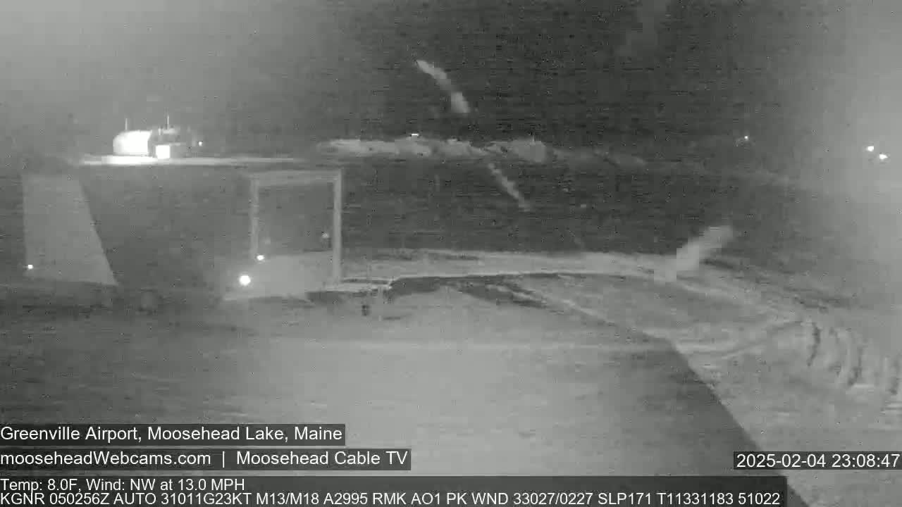A nighttime, snow-covered airfield is shown with a northwest wind at 13 mph and a temperature of 8°F.