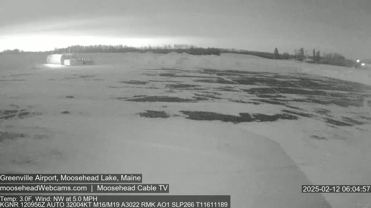 A snow-covered airfield is visible under a dark, possibly pre-dawn sky.