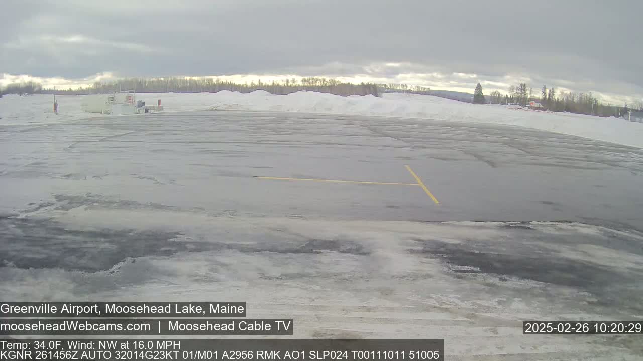 A mostly empty snow-covered airport tarmac is visible under an overcast sky.