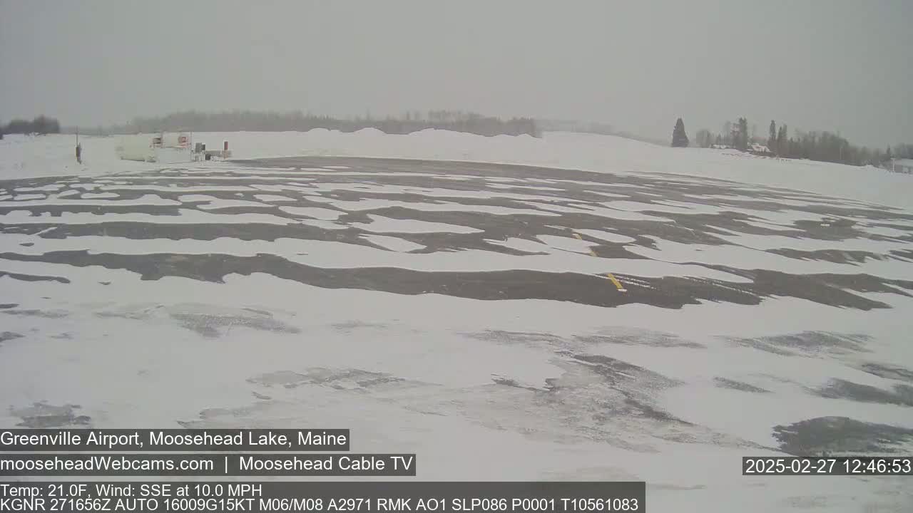 A snow-covered airport parking lot is visible under an overcast sky.