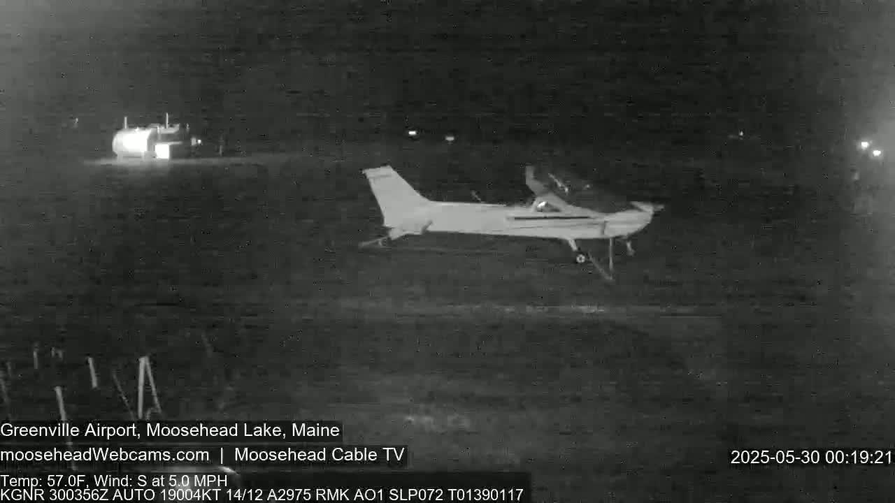 A small airplane sits on a dark airfield at night.