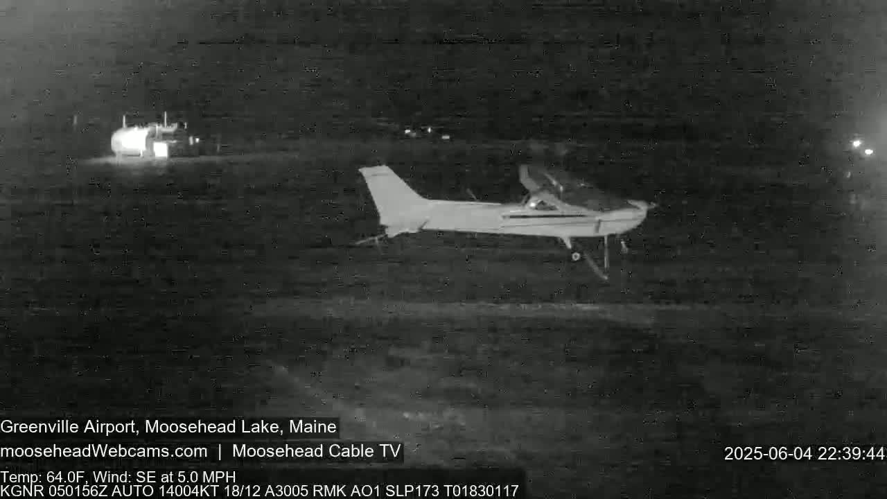 A small airplane is on the ground at night.