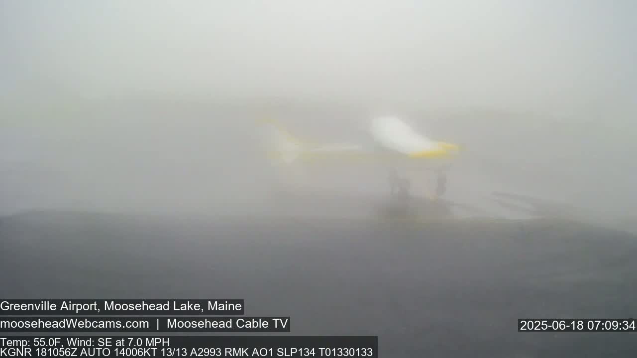 A partially visible helicopter sits on a foggy tarmac.